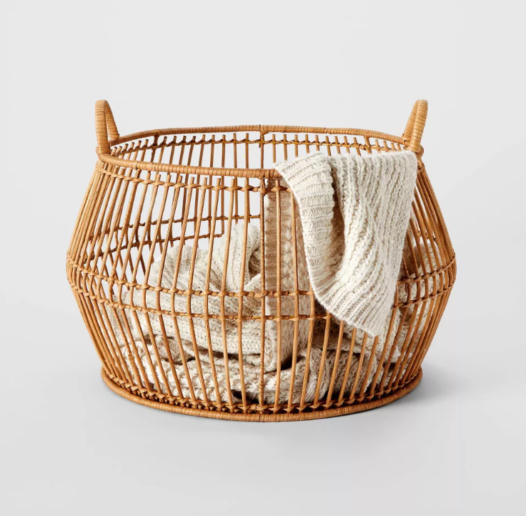A wicker basket with a blanket in it
