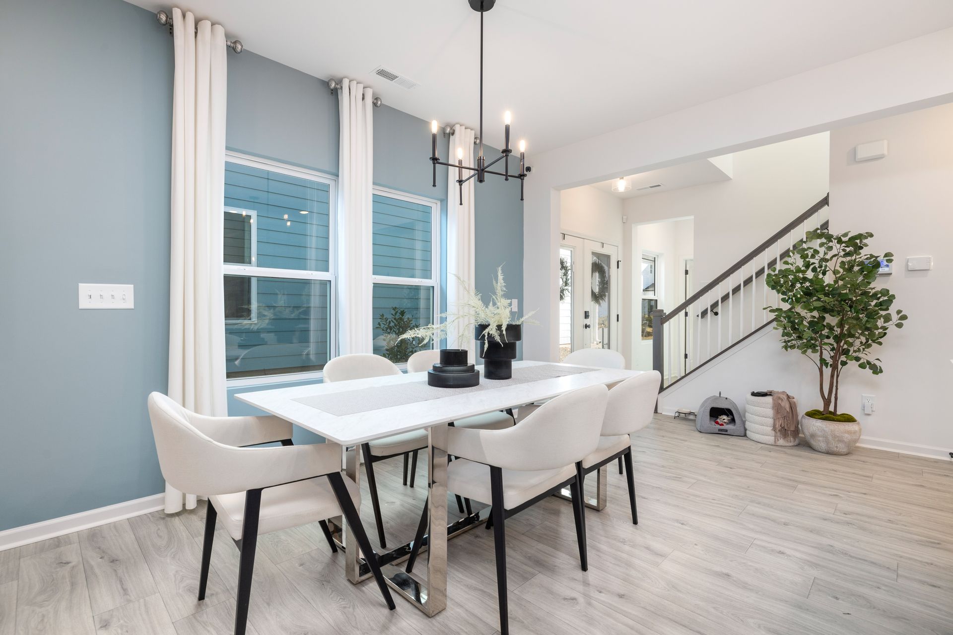 A dining room with a table and chairs and a chandelier.