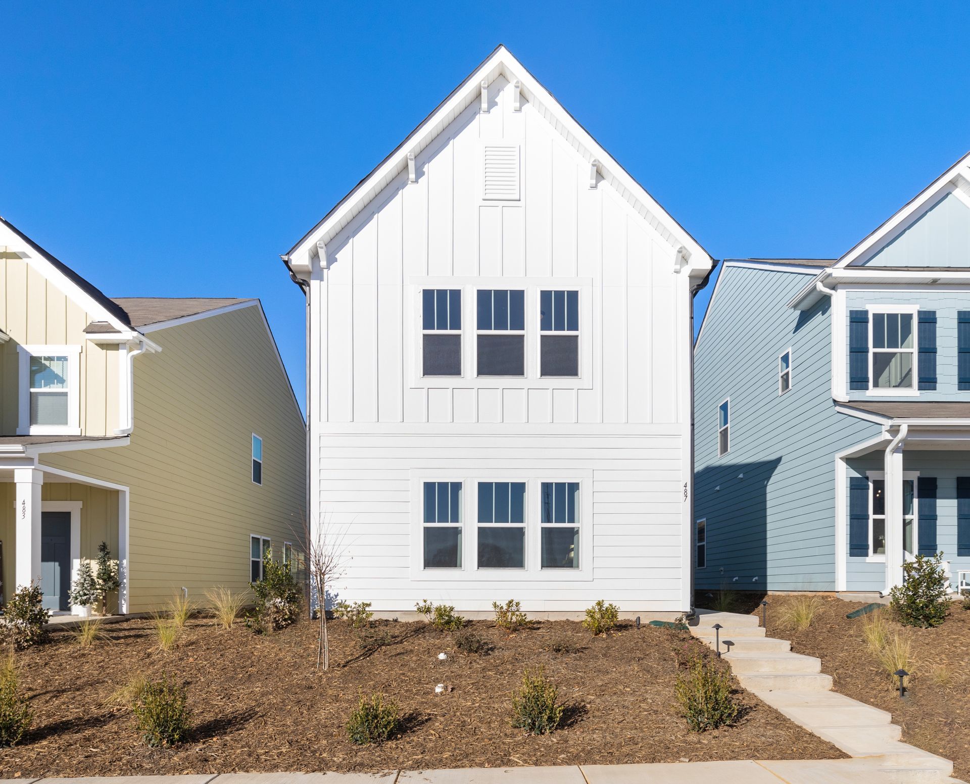 A row of houses are lined up next to each other on a sunny day.