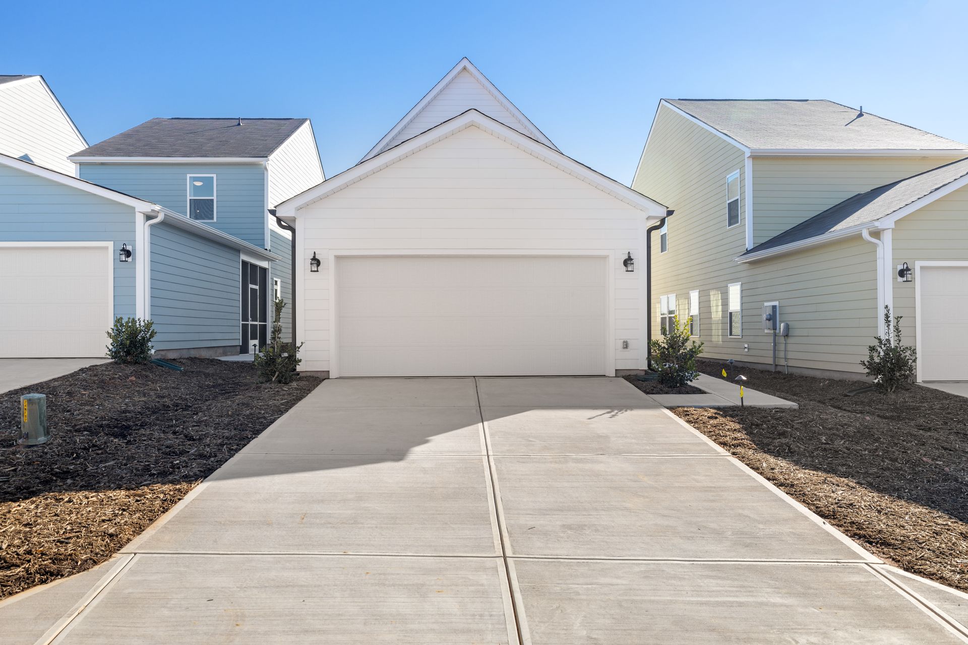 A white house with a concrete driveway in front of it
