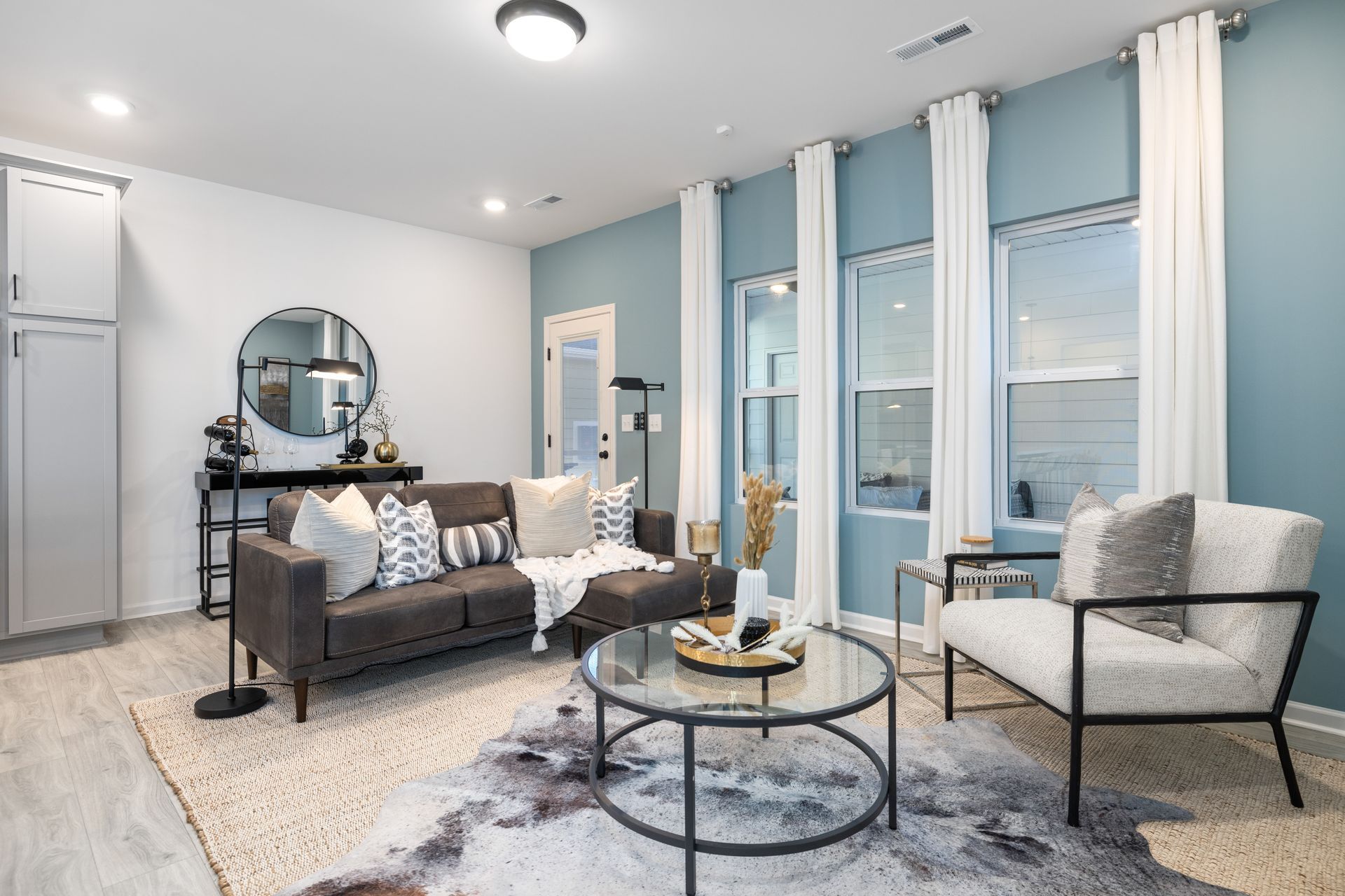 A living room with a couch , chair , coffee table and blue walls.