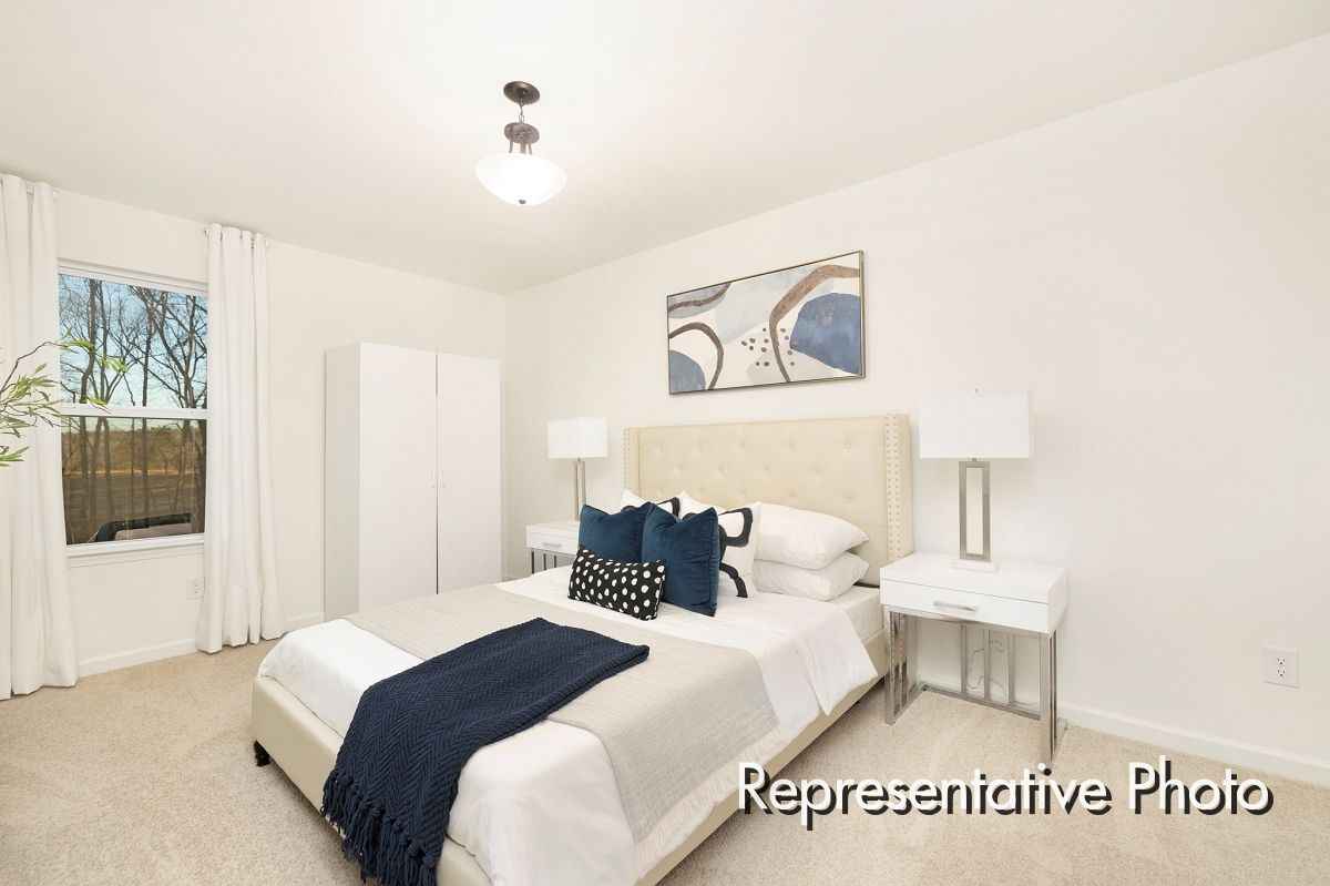 A bedroom with a large bed and a window.