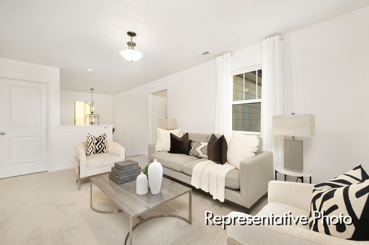A living room with a couch , chairs and a coffee table.
