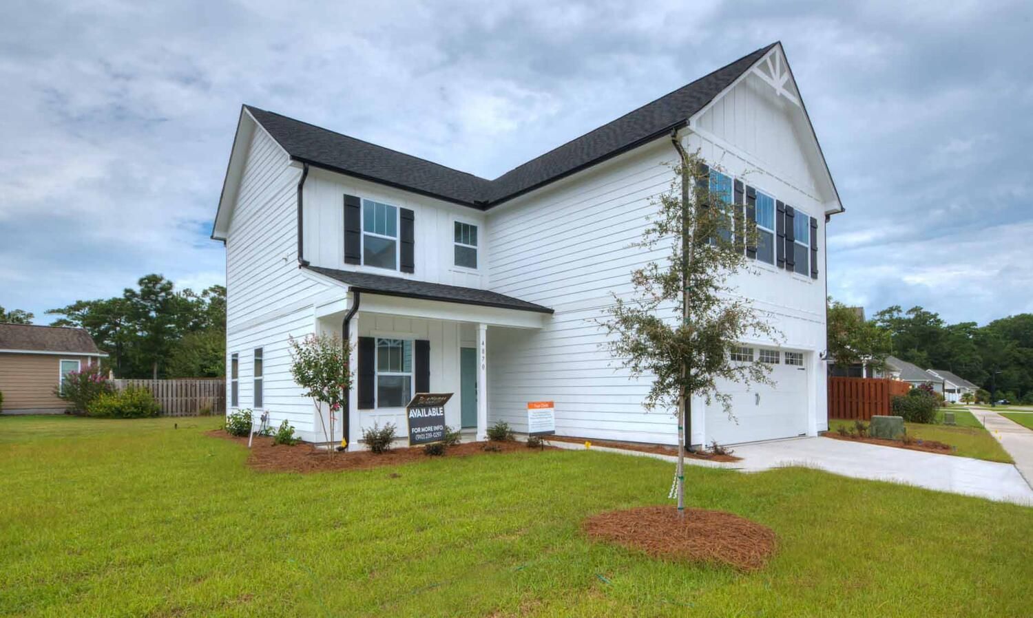 A large white house with a black roof and black shutters