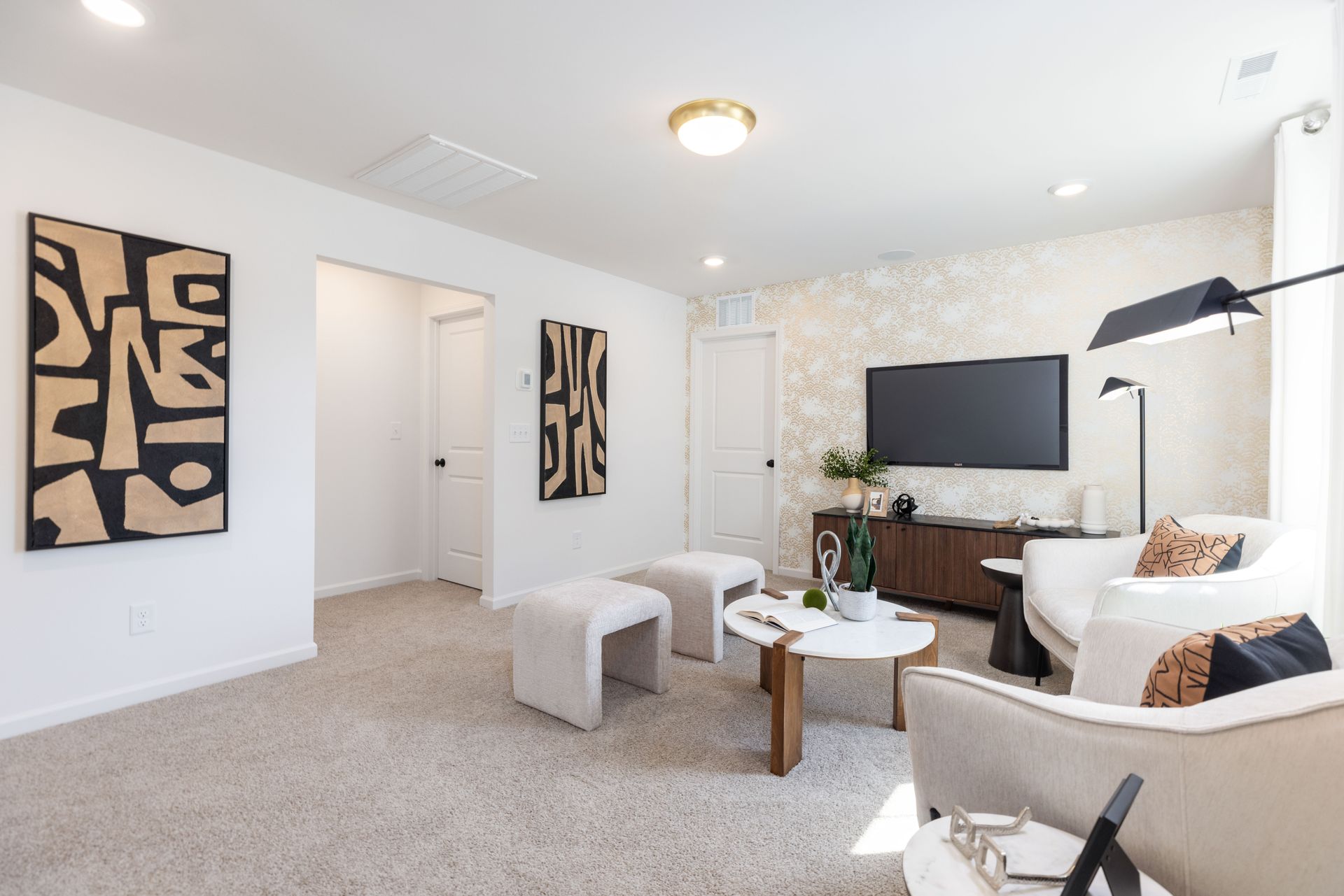 A living room with a couch , chairs , table and television.