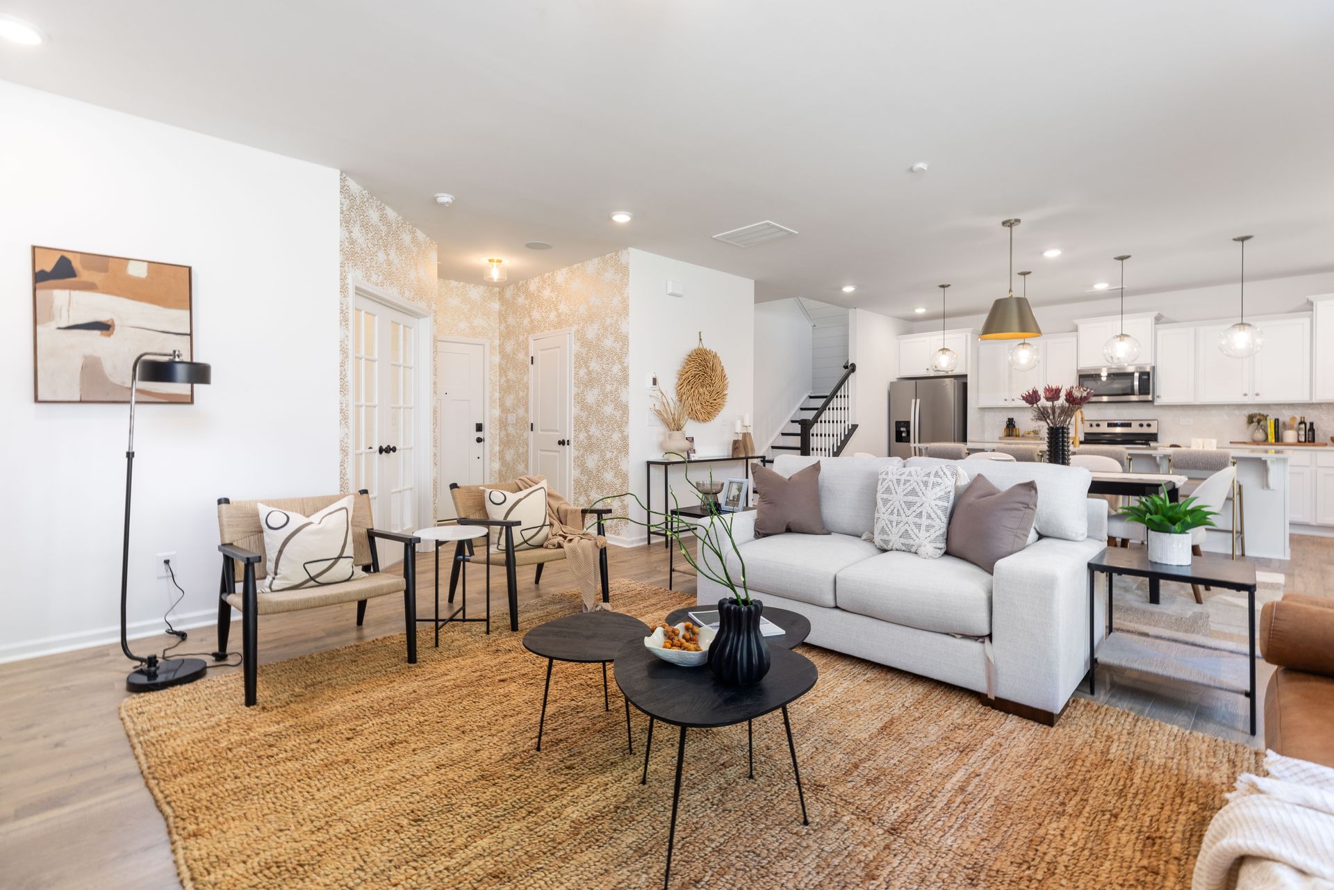 A living room with a couch , chairs , tables and a rug.