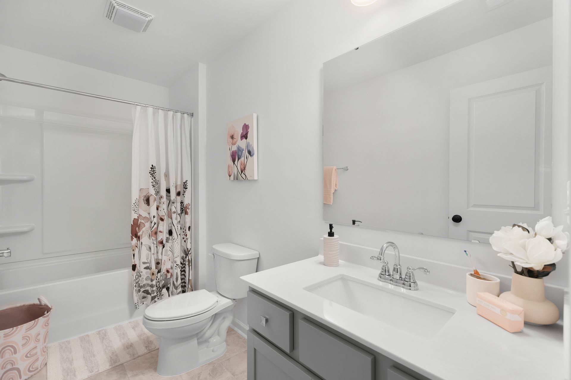 A bathroom with a toilet , sink , bathtub and mirror.