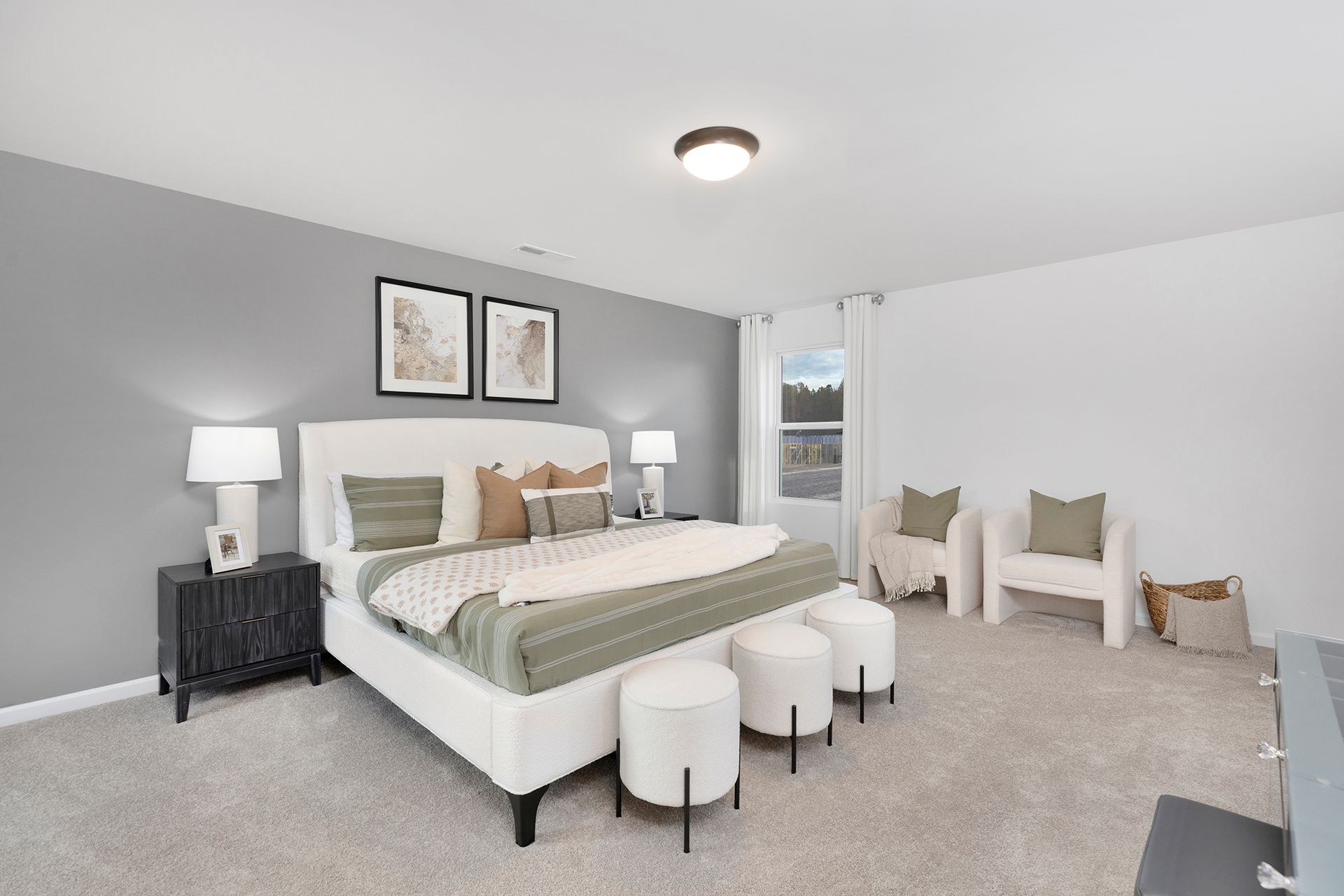 A bedroom with a bed , chairs , lamps and a window.