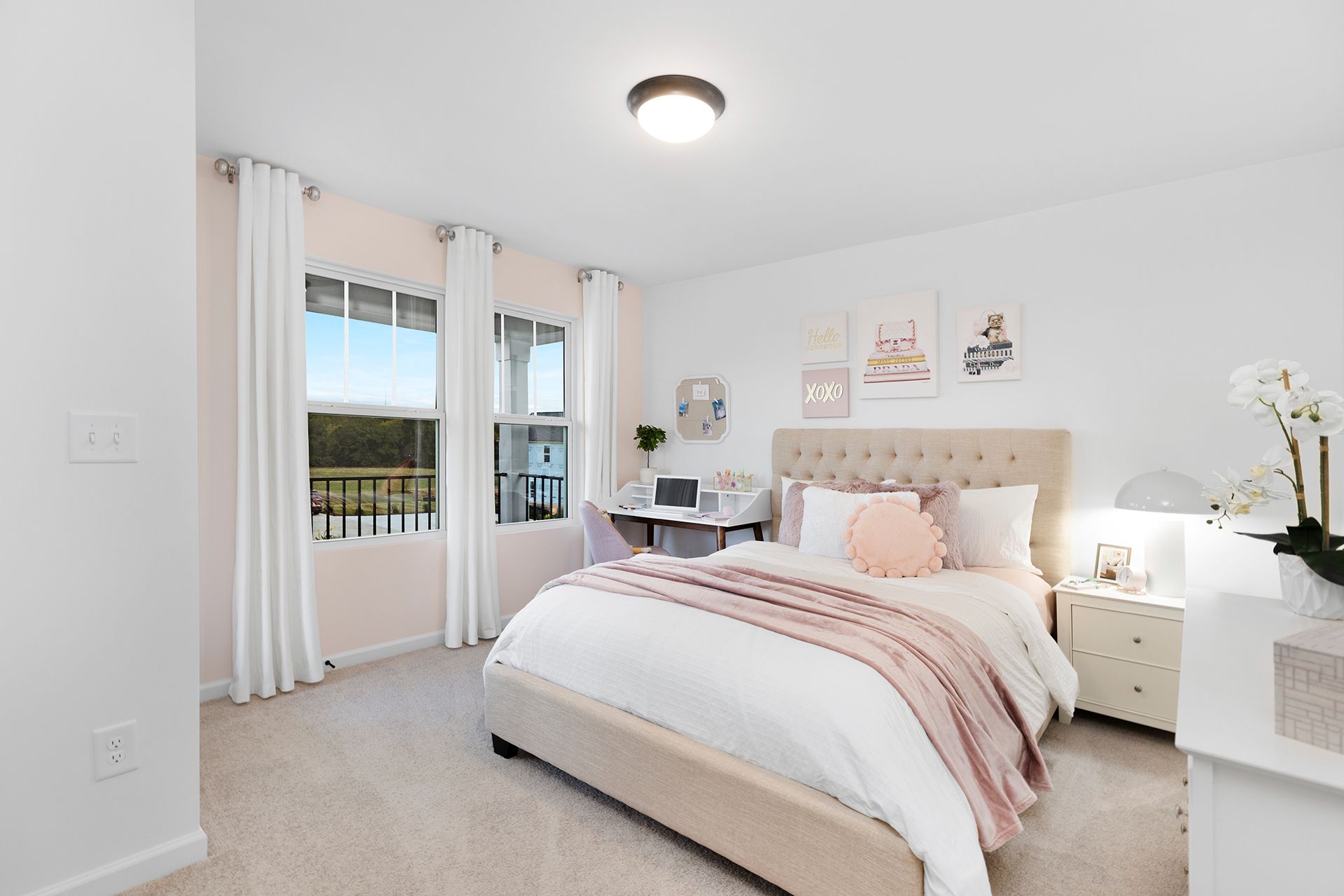 A bedroom with a bed , dresser , desk and window.