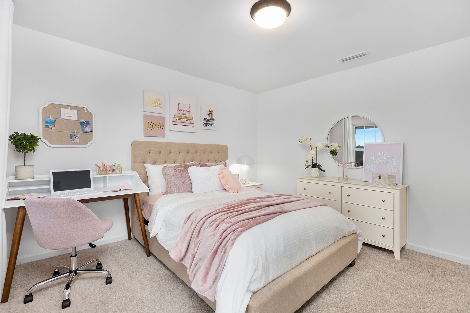 A bedroom with a bed , dresser , desk and window.