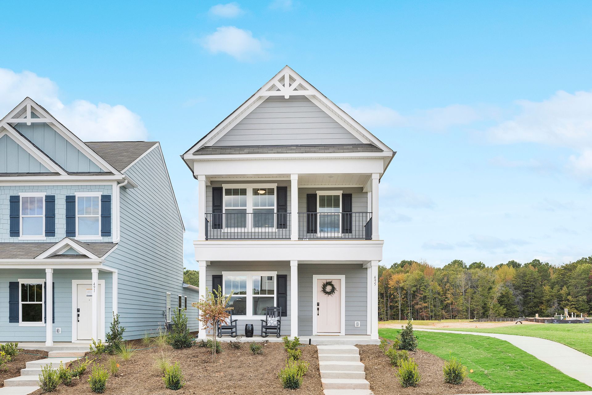 A couple of houses are sitting next to each other on a lush green hillside.