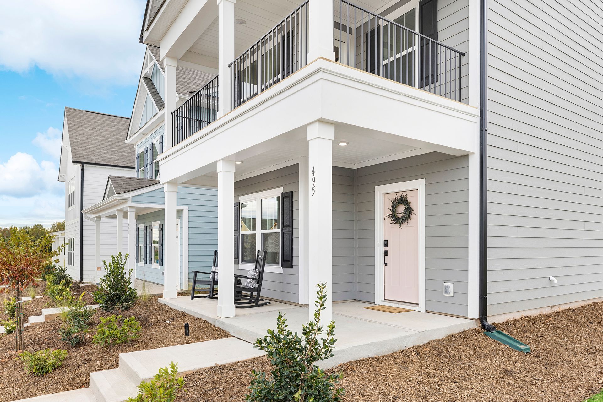 A house with a large porch and a pink door.