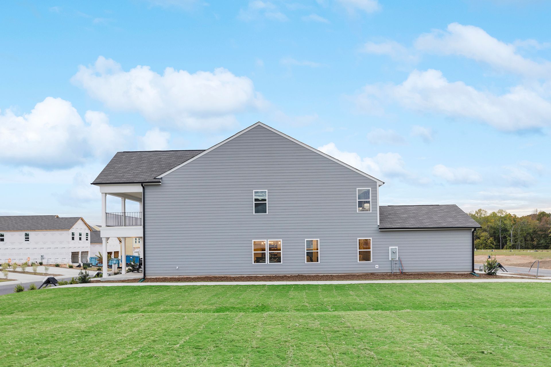 A large house is sitting on top of a lush green field.
