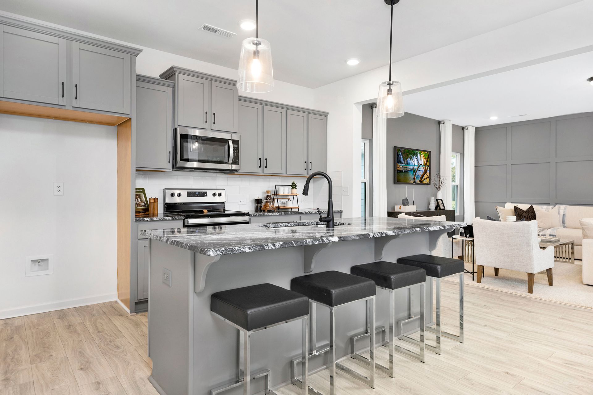 A kitchen with a large island and stools in a house.