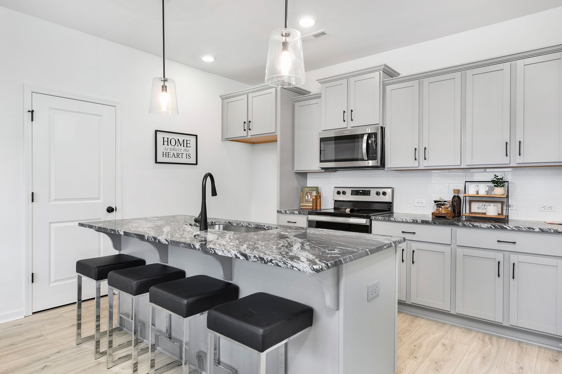 A kitchen with white cabinets and granite counter tops