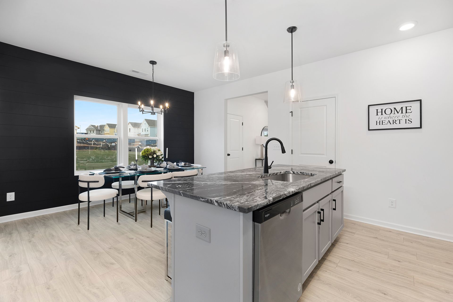 A kitchen with a large island and a dining room in the background.