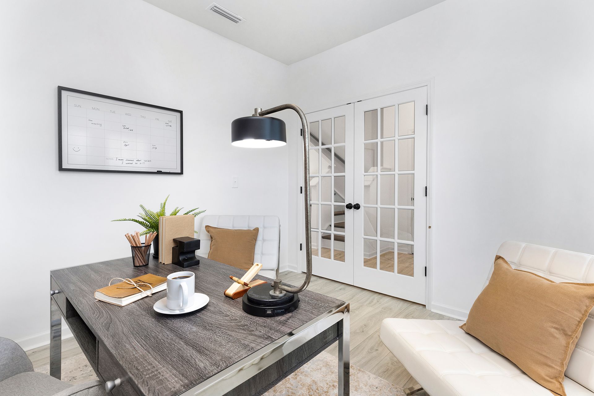 A living room with a table , chairs , and a lamp.
