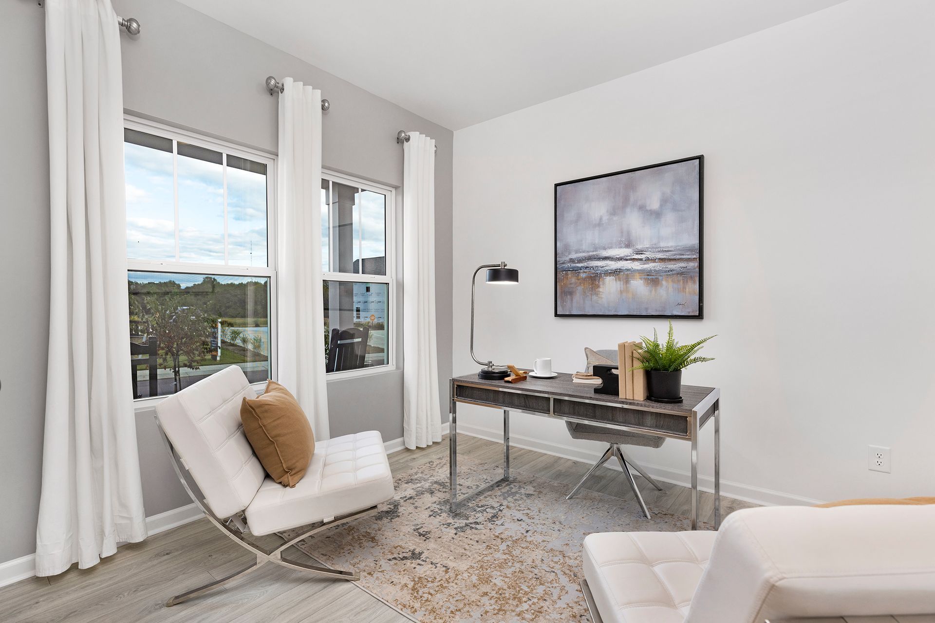 A home office with a desk , chair and painting on the wall.