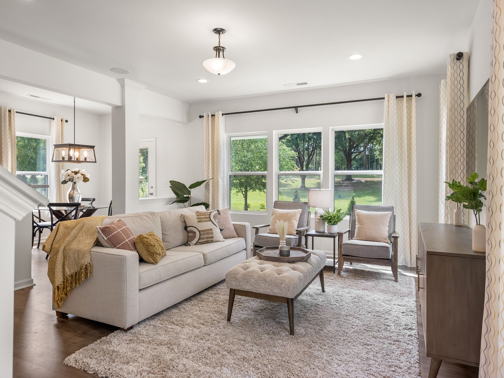 A living room with a couch , chairs , and a rug.