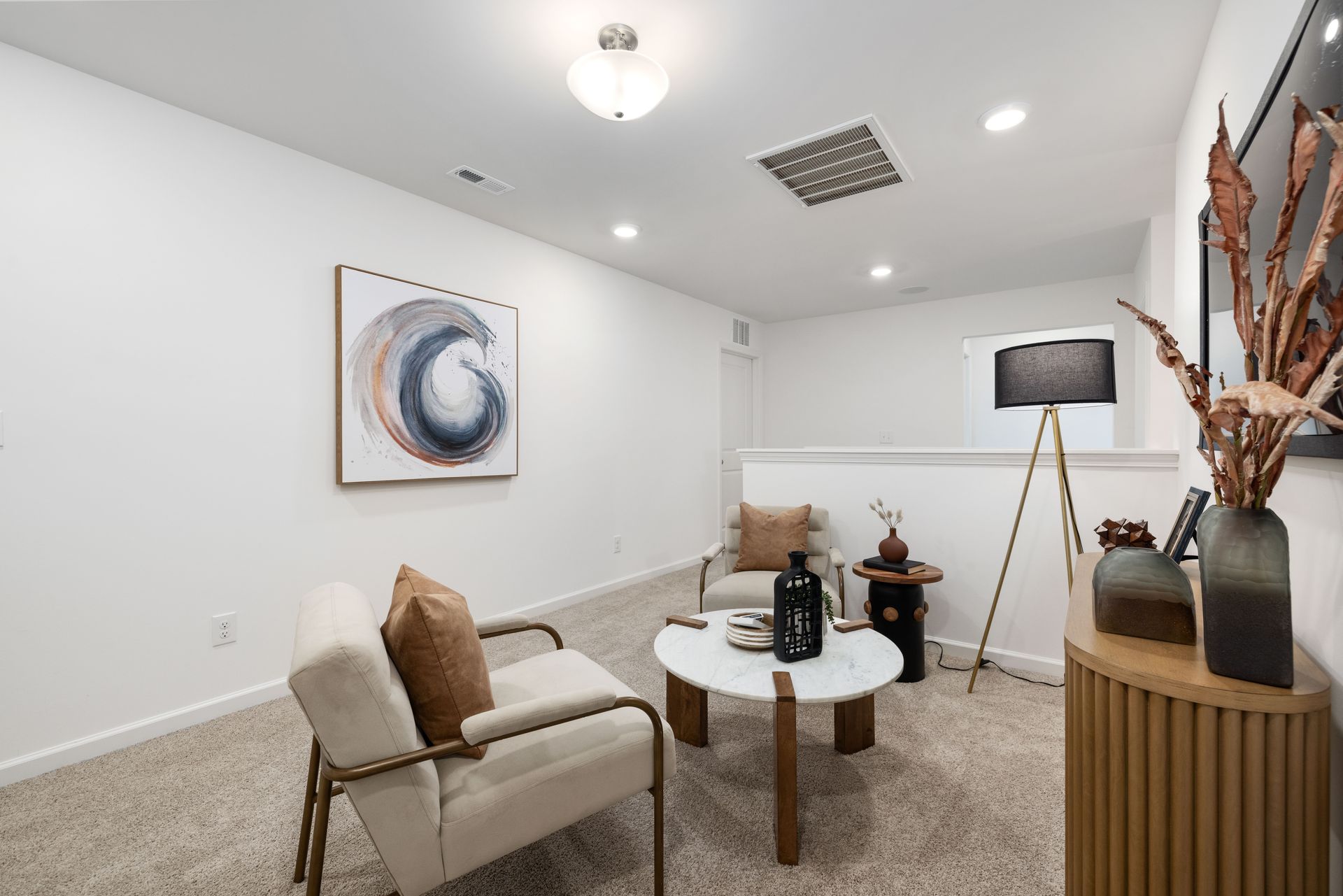 A living room with a couch , chair , coffee table and lamp.