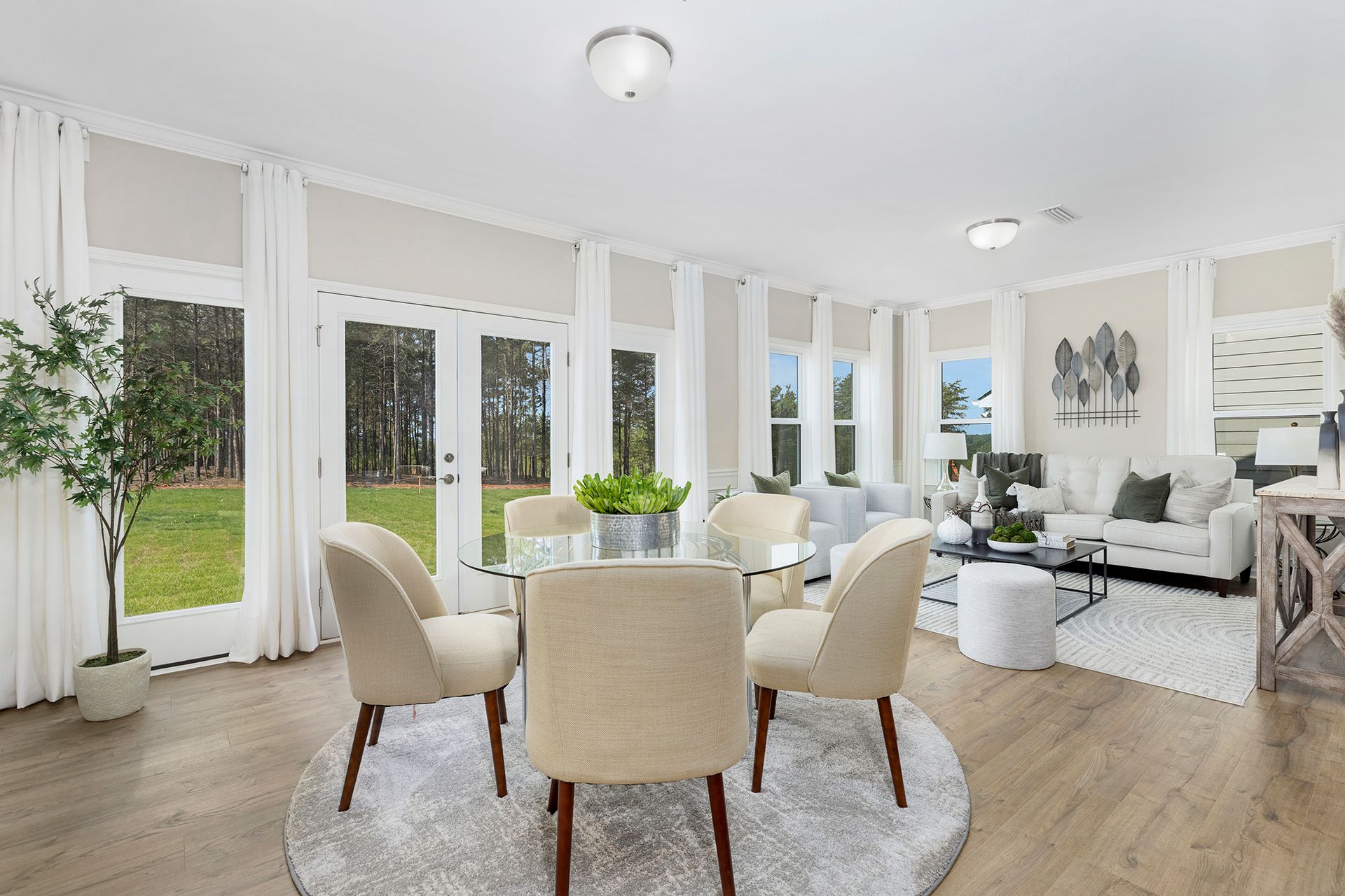 A dining room with a round table and chairs in a living room.