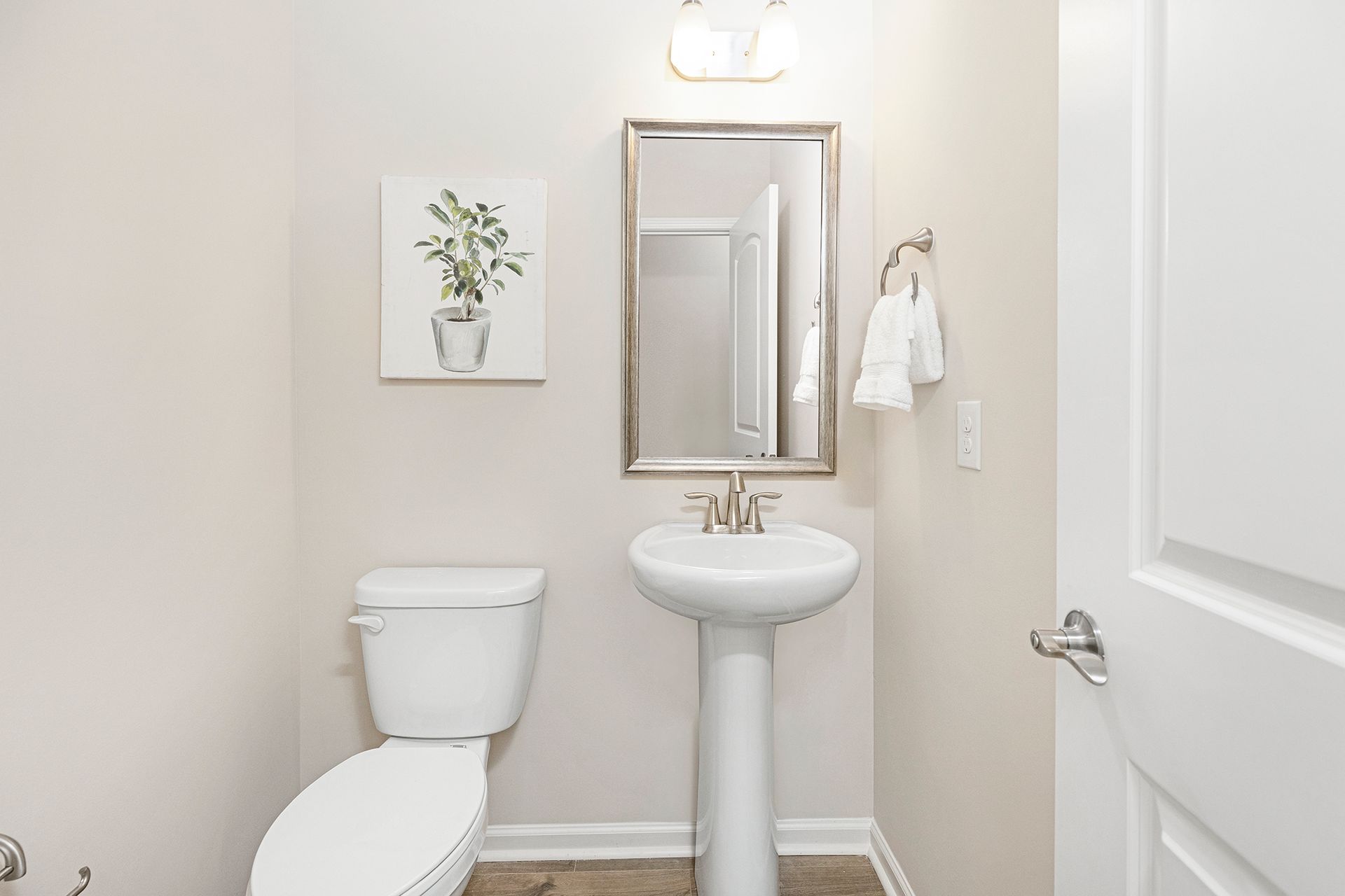 A bathroom with a toilet , sink and mirror.