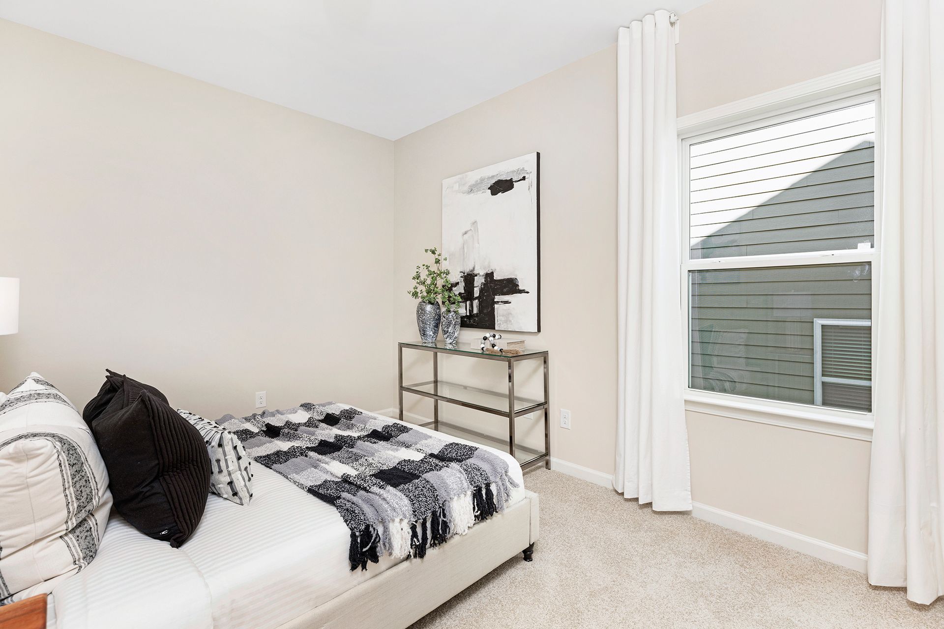 A bedroom with a bed , nightstand , and window.