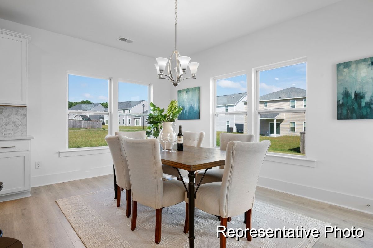 A dining room with a table and chairs and a chandelier.