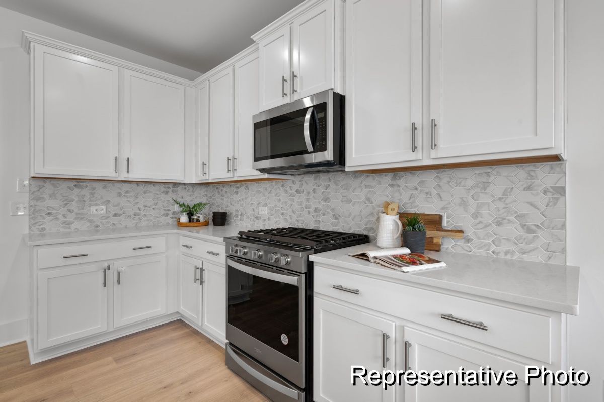 A kitchen with white cabinets and stainless steel appliances.