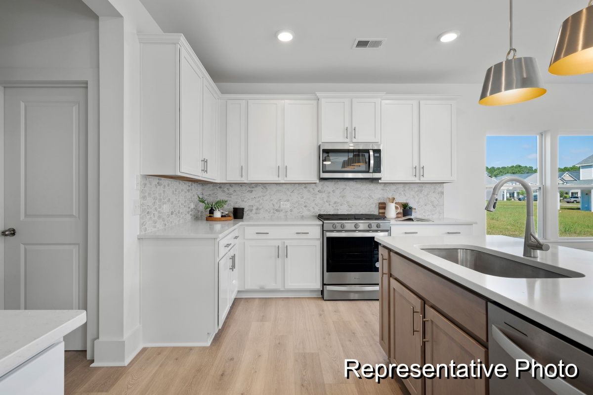 A kitchen with white cabinets and stainless steel appliances.