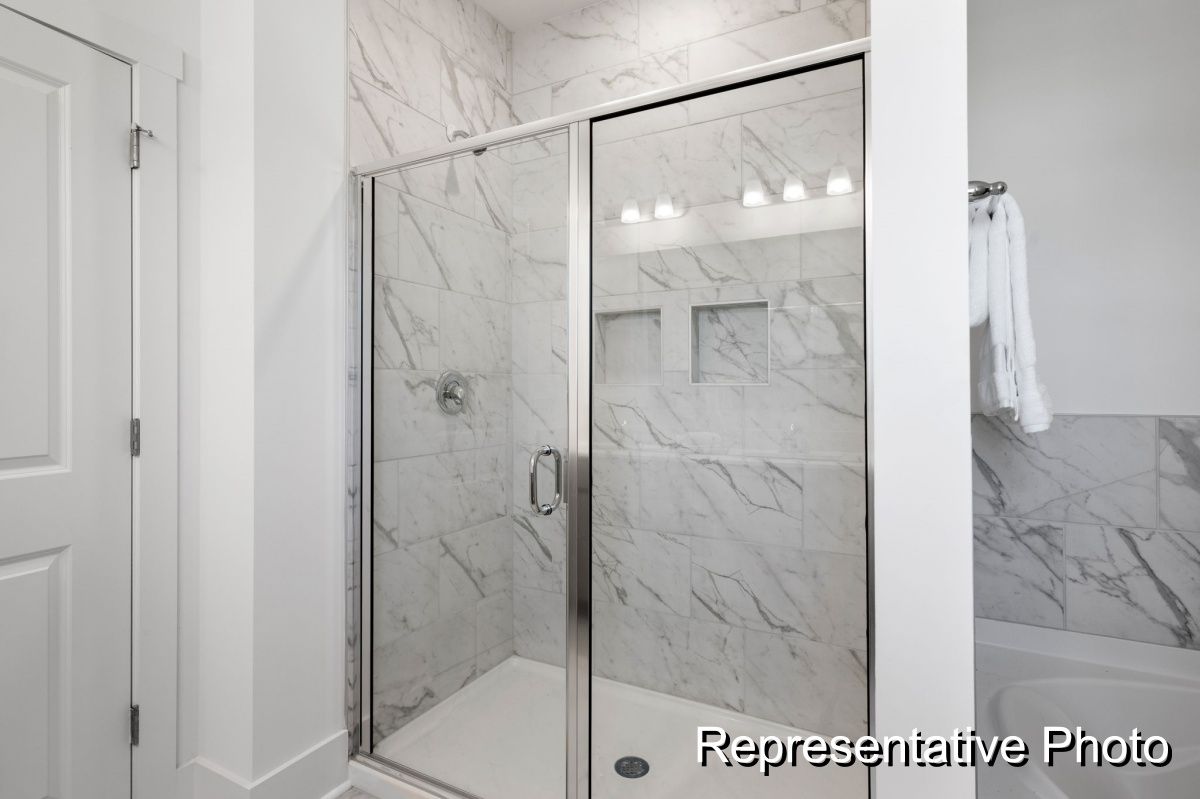 A bathroom with a walk in shower and a bathtub.
