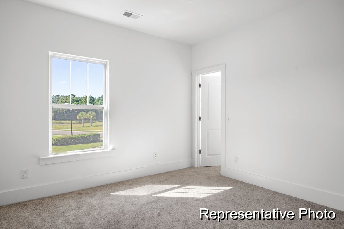 An empty bedroom with a window and a door.