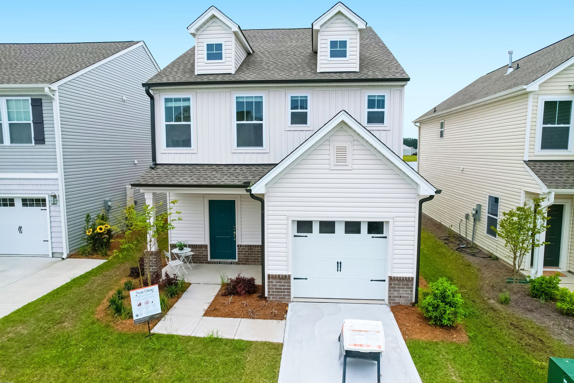 An aerial view of a white house with a green door.