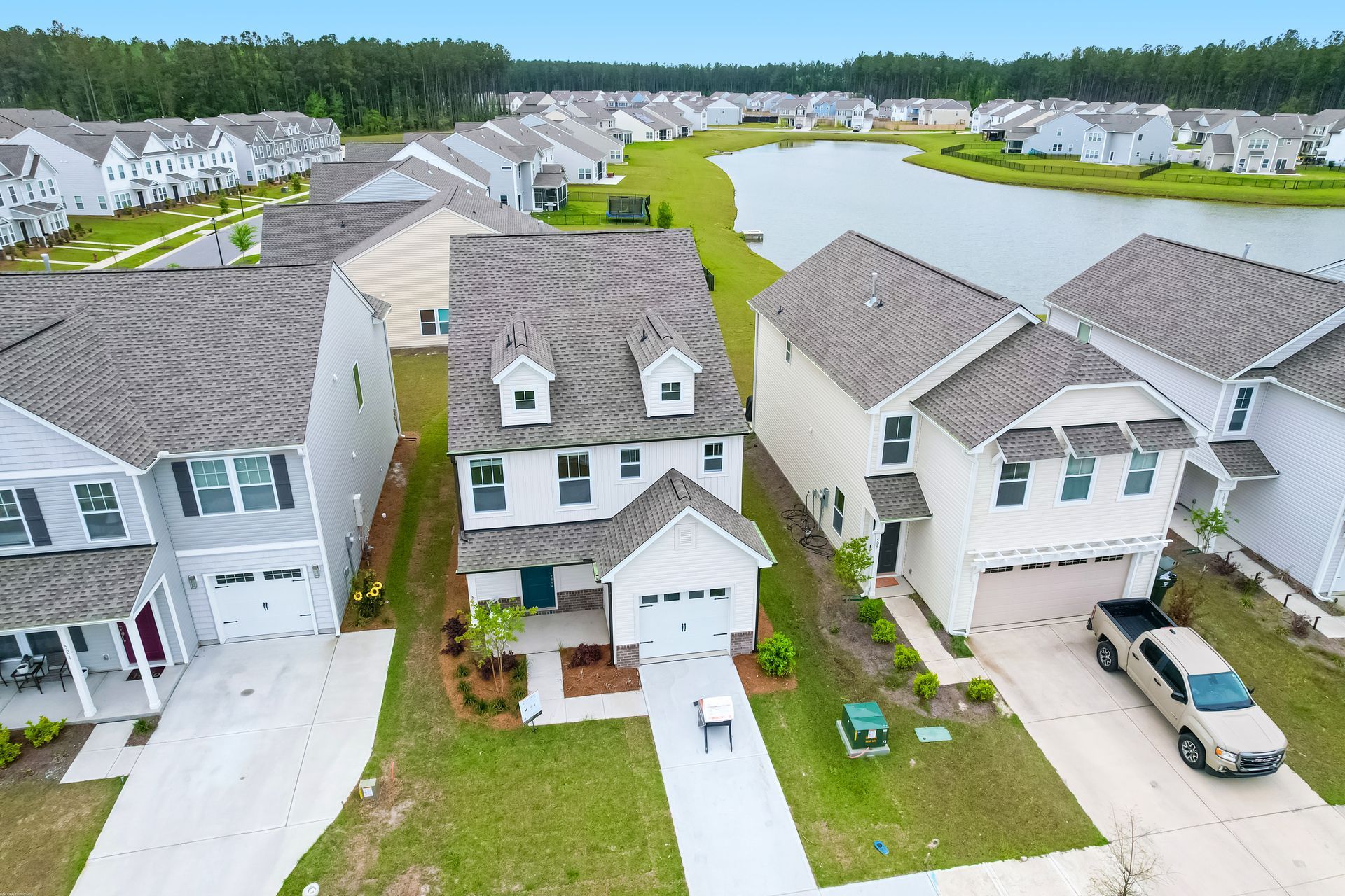 An aerial view of a residential neighborhood with a lake in the background