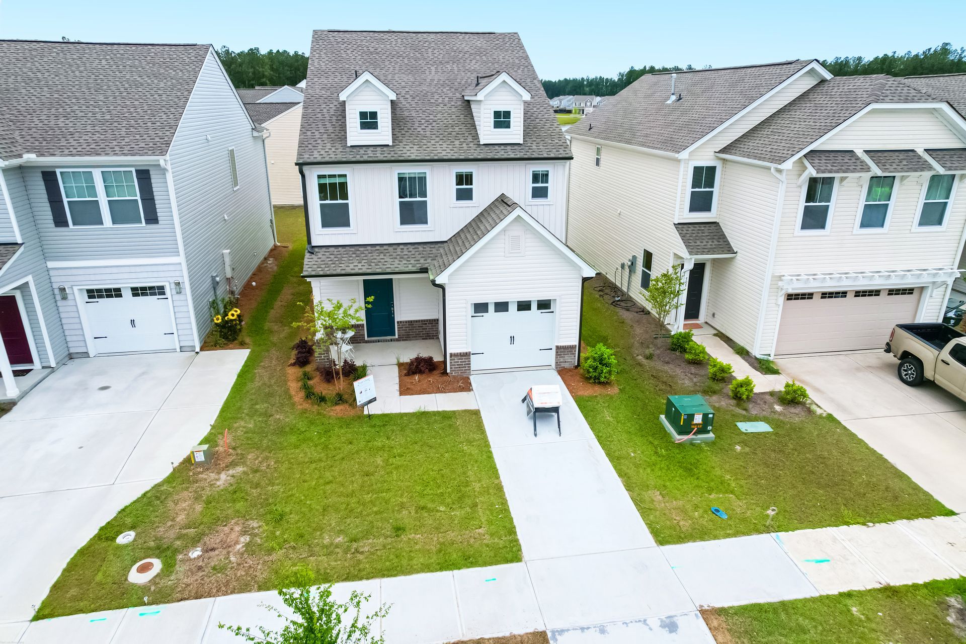 An aerial view of a house in a residential area with a truck parked in front of it.