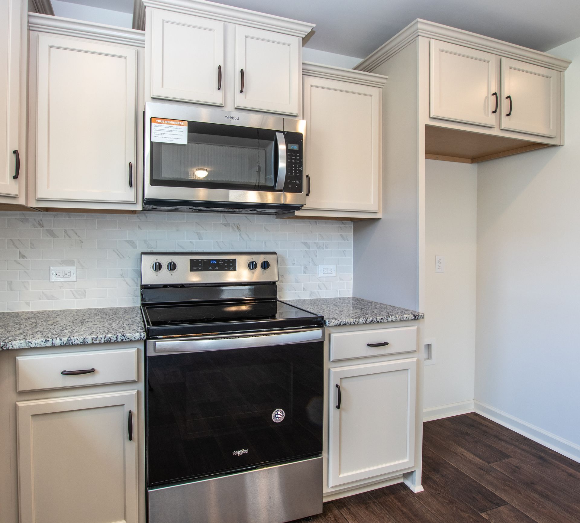 A kitchen with stainless steel appliances and white cabinets