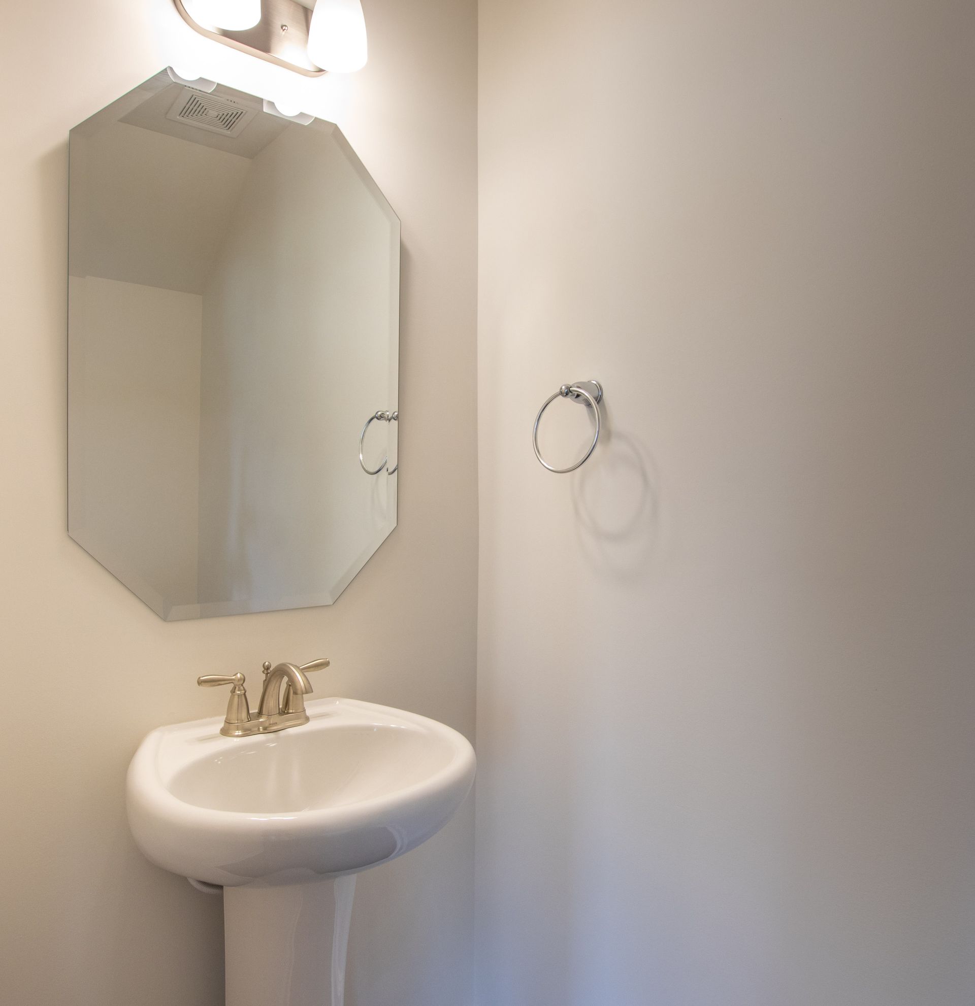 A bathroom with a pedestal sink and a mirror
