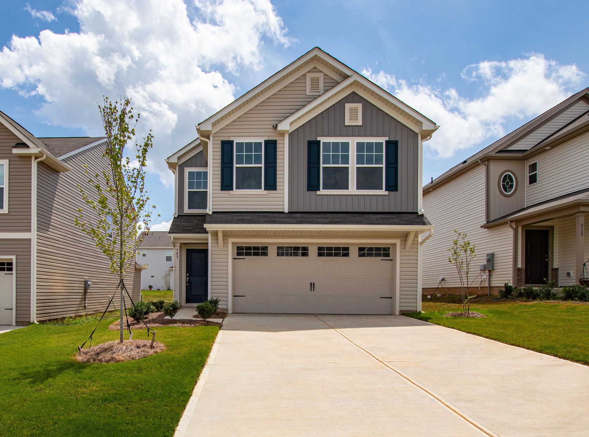A large house with a garage and a driveway in front of it.