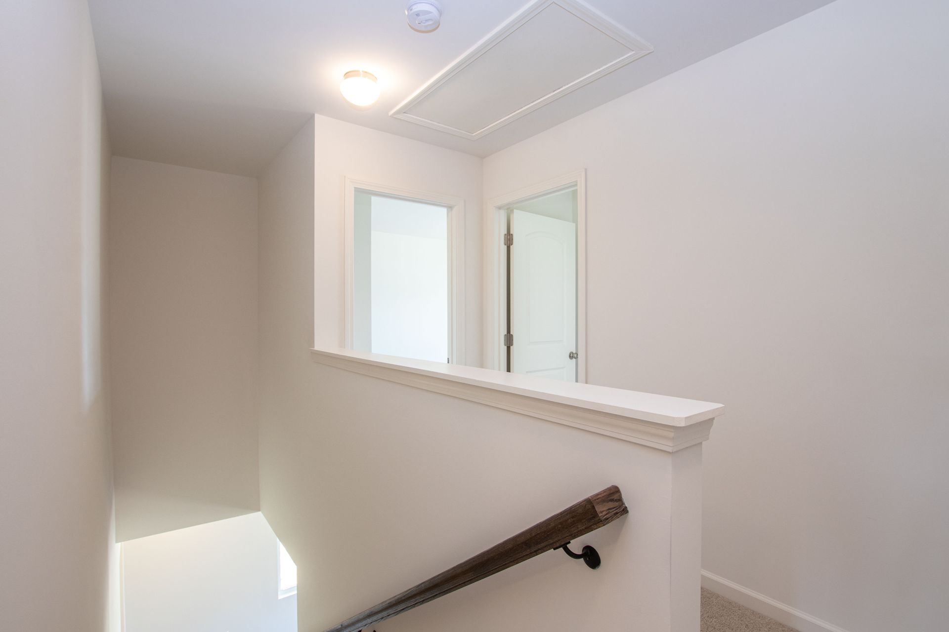 A hallway with stairs leading up to the second floor of a house.