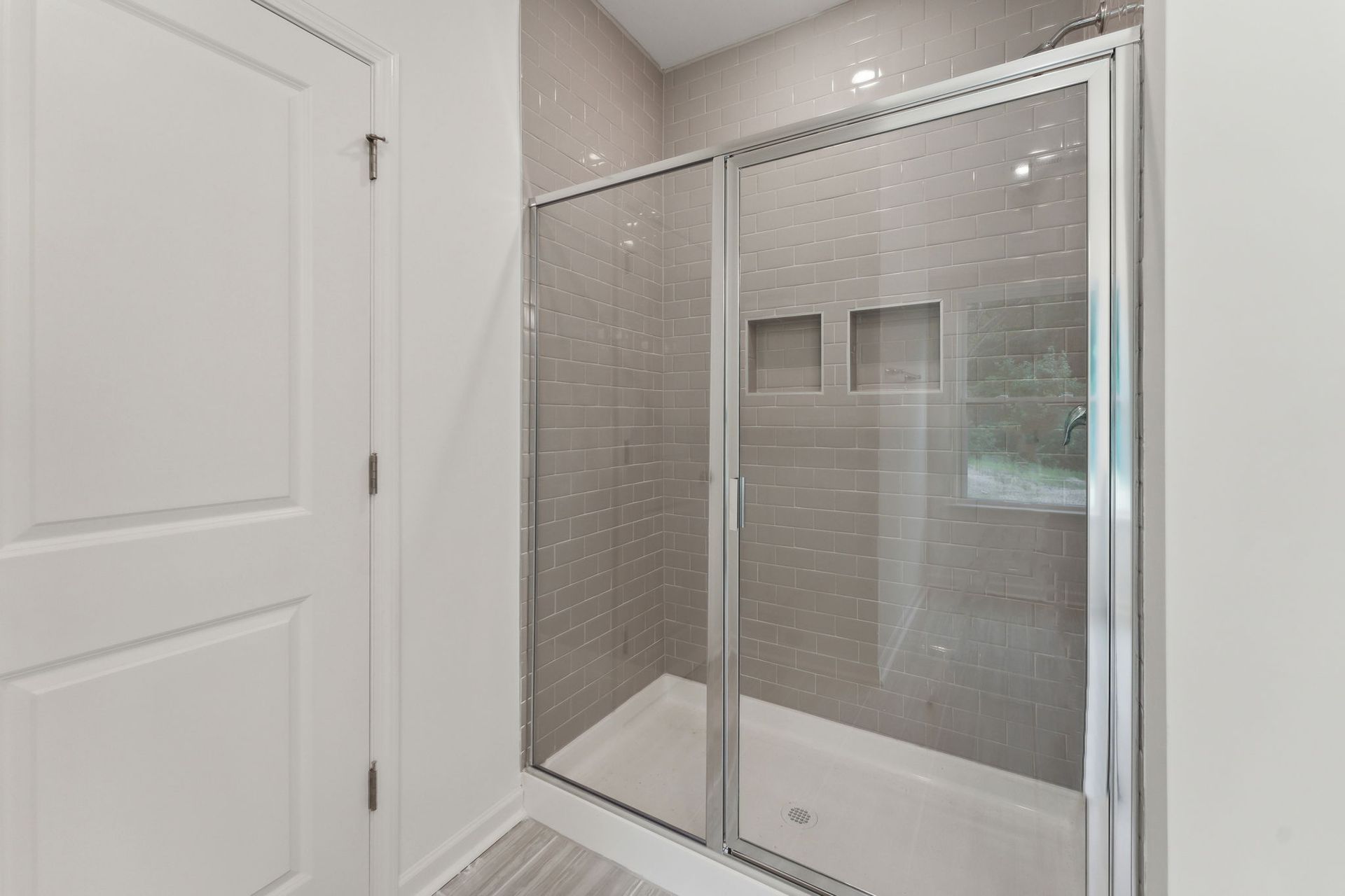A bathroom with a sliding glass shower door.