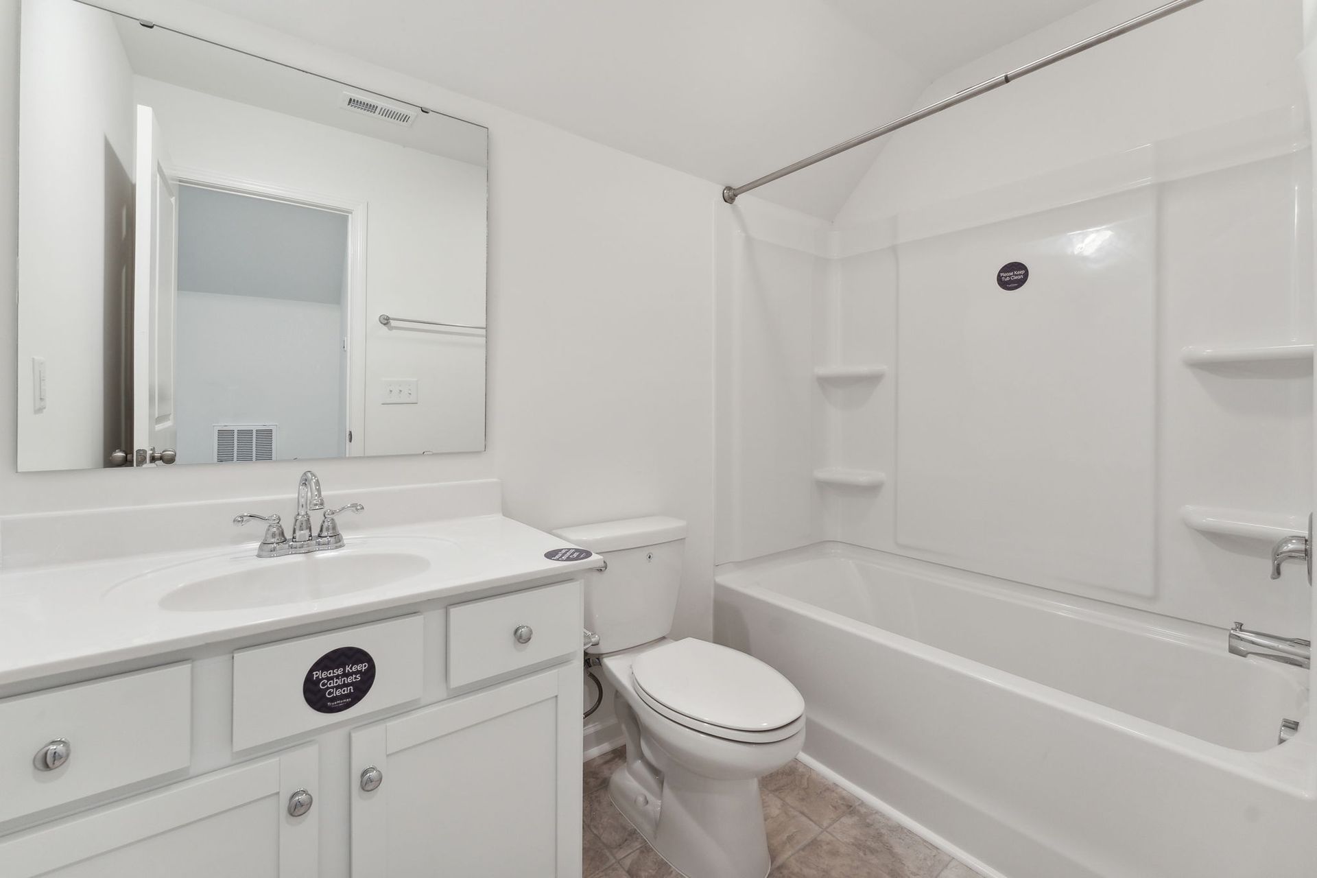 A bathroom with a toilet , sink , and bathtub.