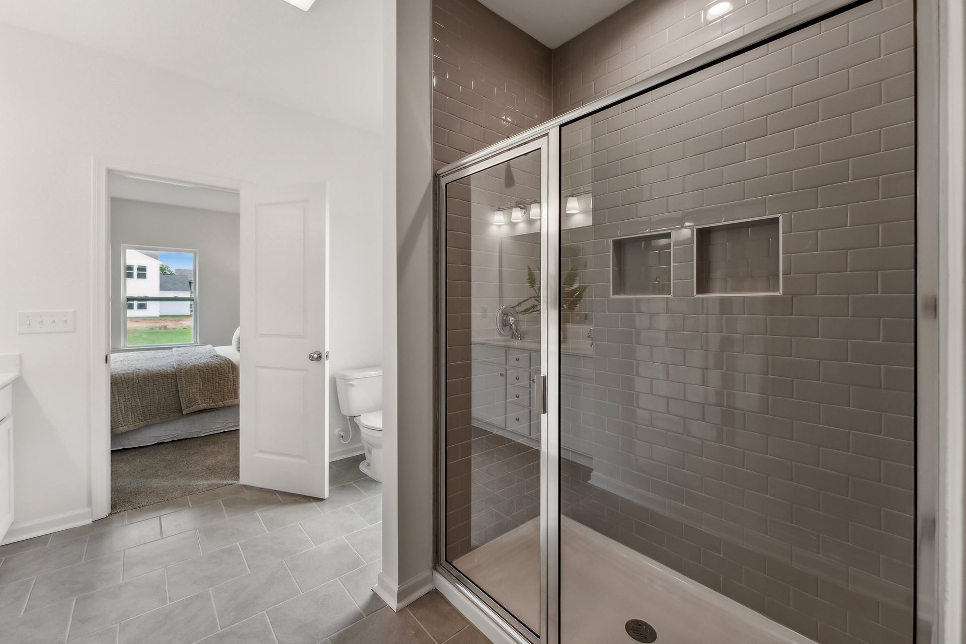 A bathroom with a walk in shower and a toilet.