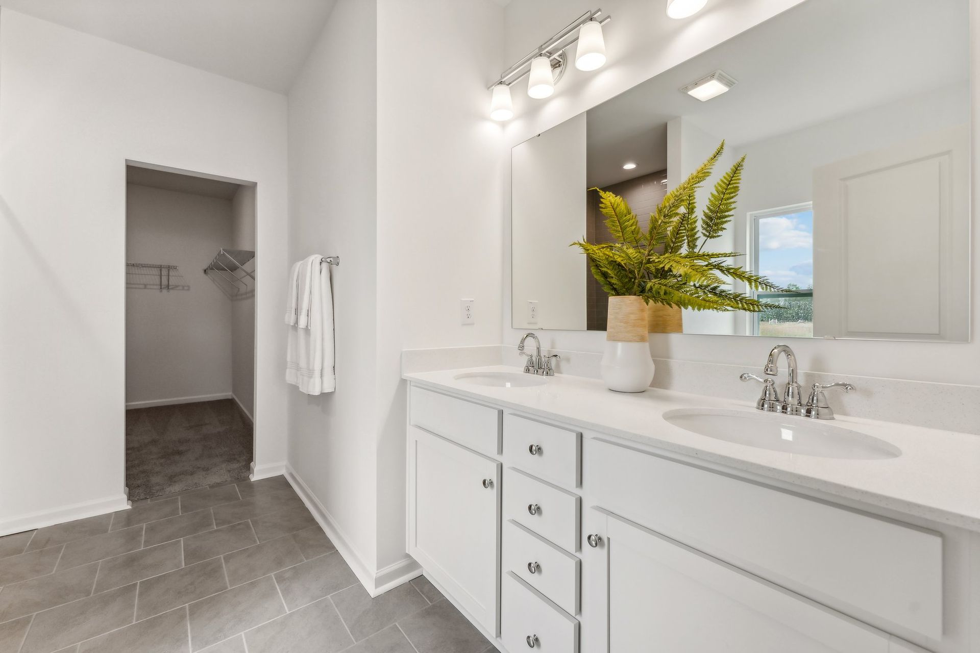 A bathroom with two sinks and a large mirror.