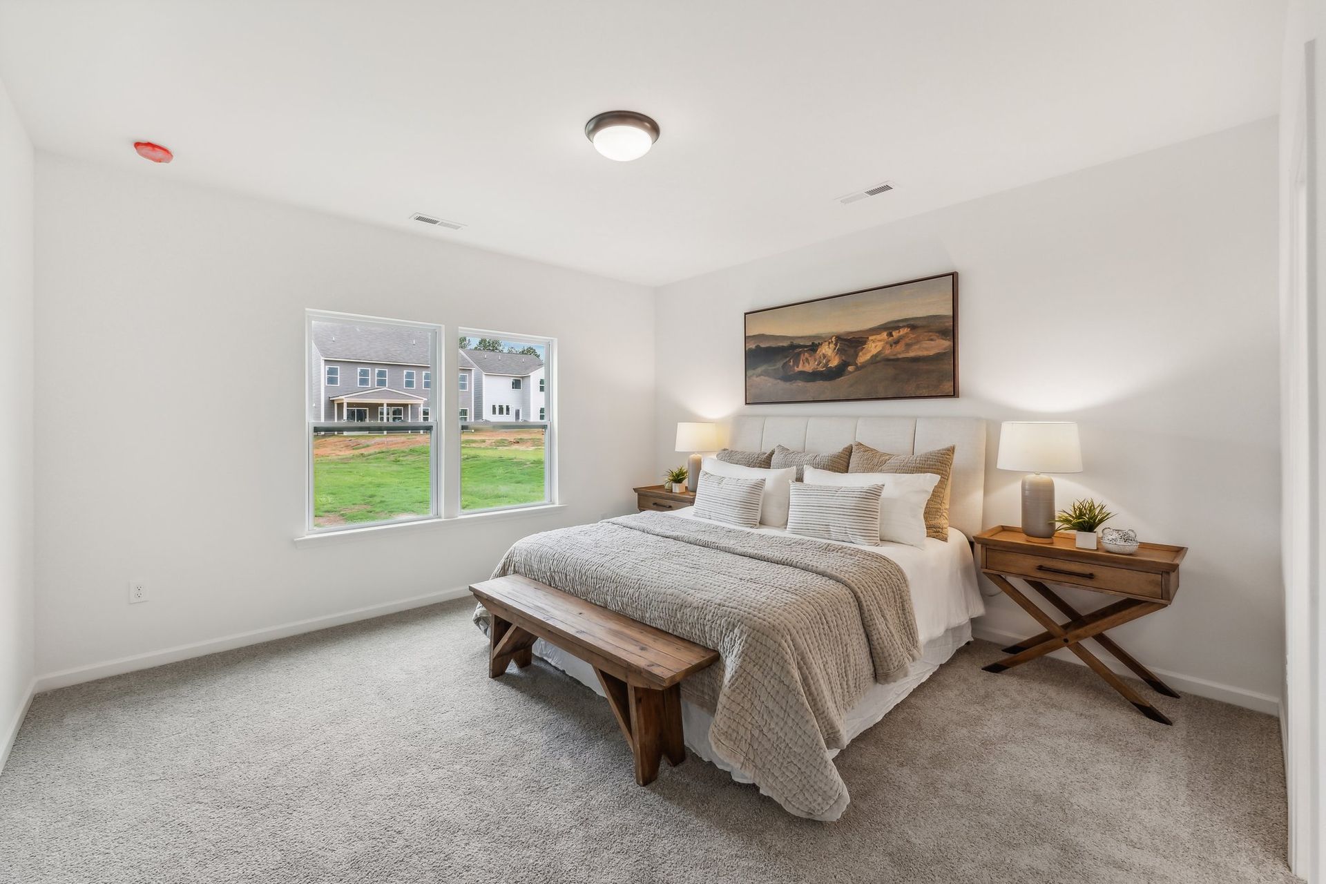 A bedroom with a king size bed and a bench.