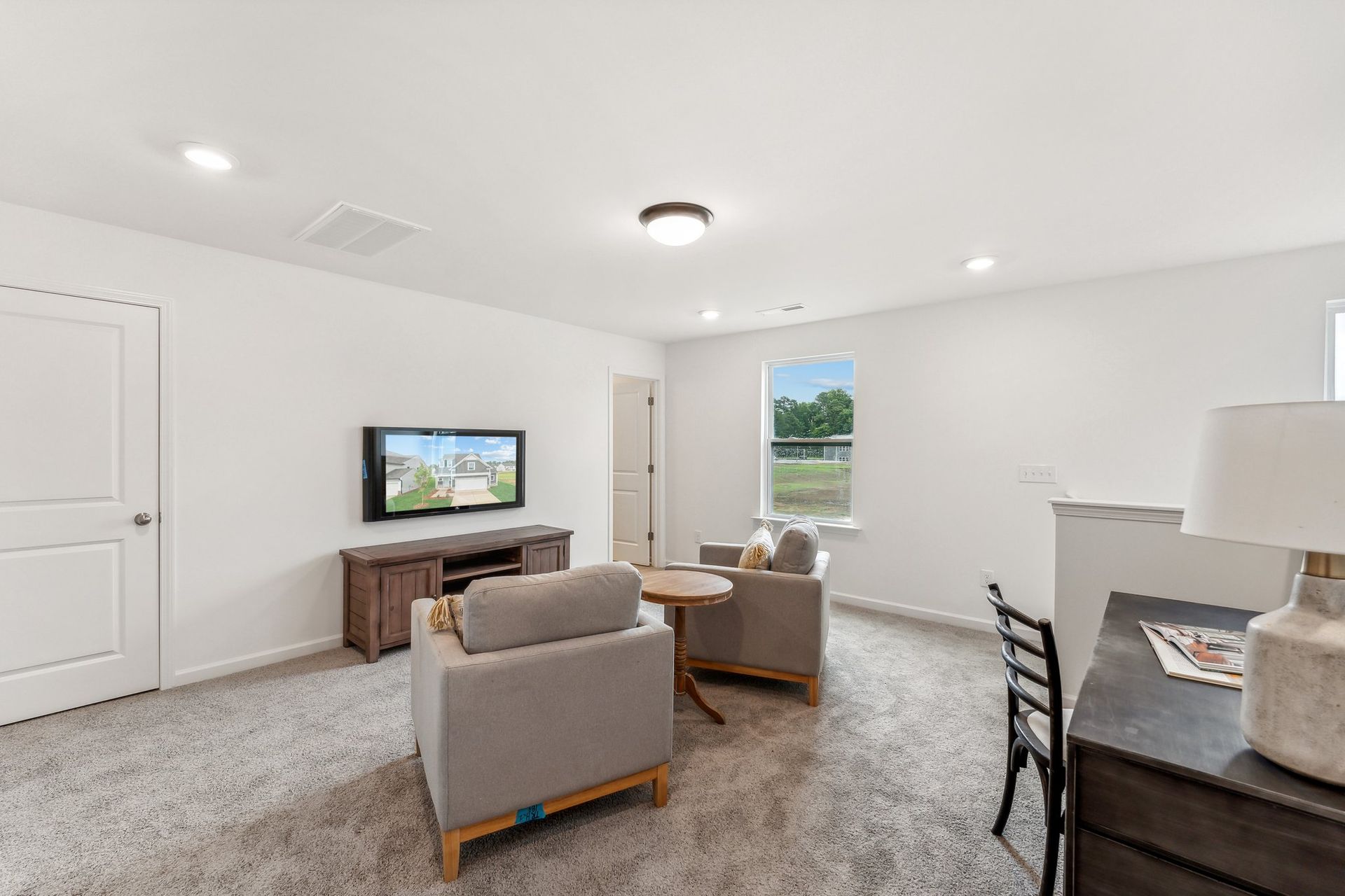 A living room with a couch , chairs , table and television.