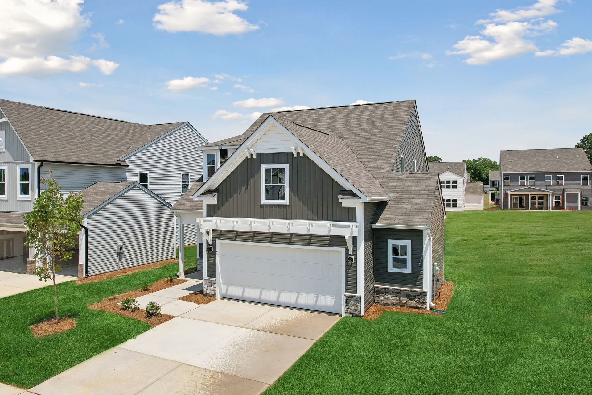 An aerial view of a house with a large garage in a residential area.
