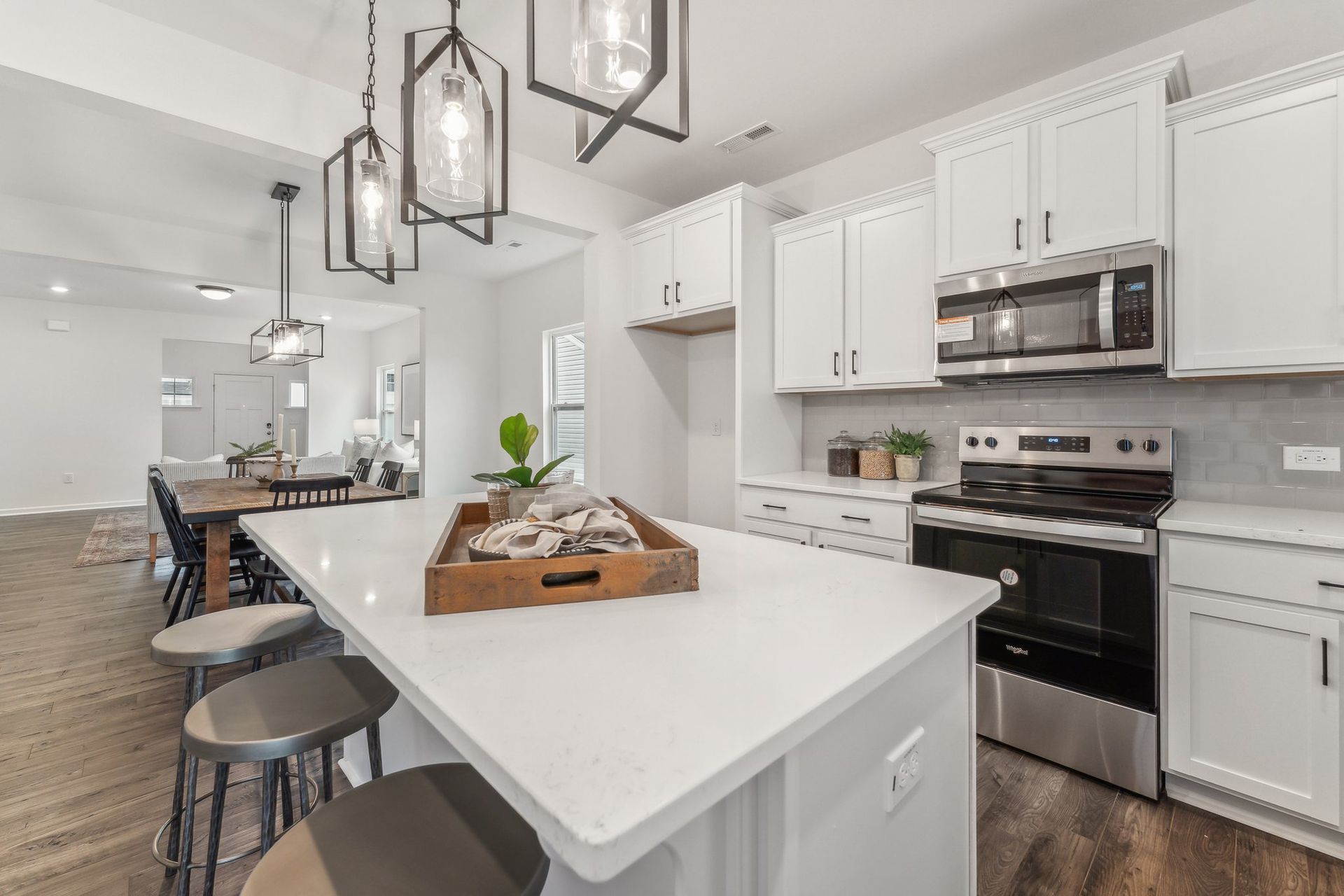 A kitchen with white cabinets , stainless steel appliances , and a large island.