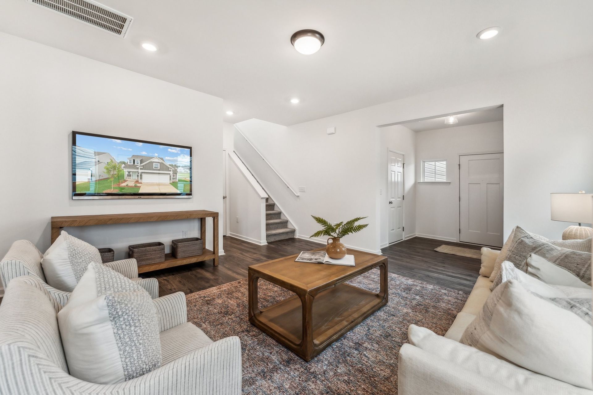 A living room with a couch , chair , coffee table and television.