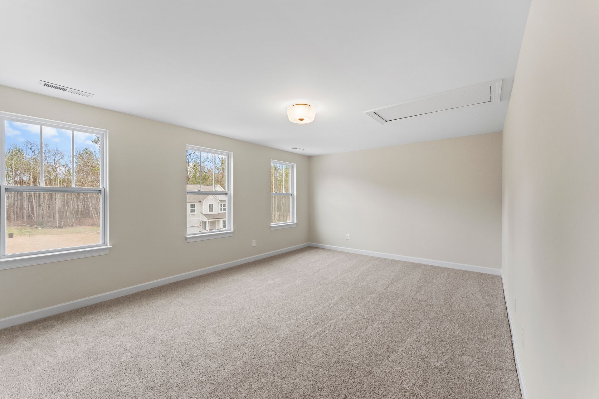 An empty room with a lot of windows and a ceiling fan.