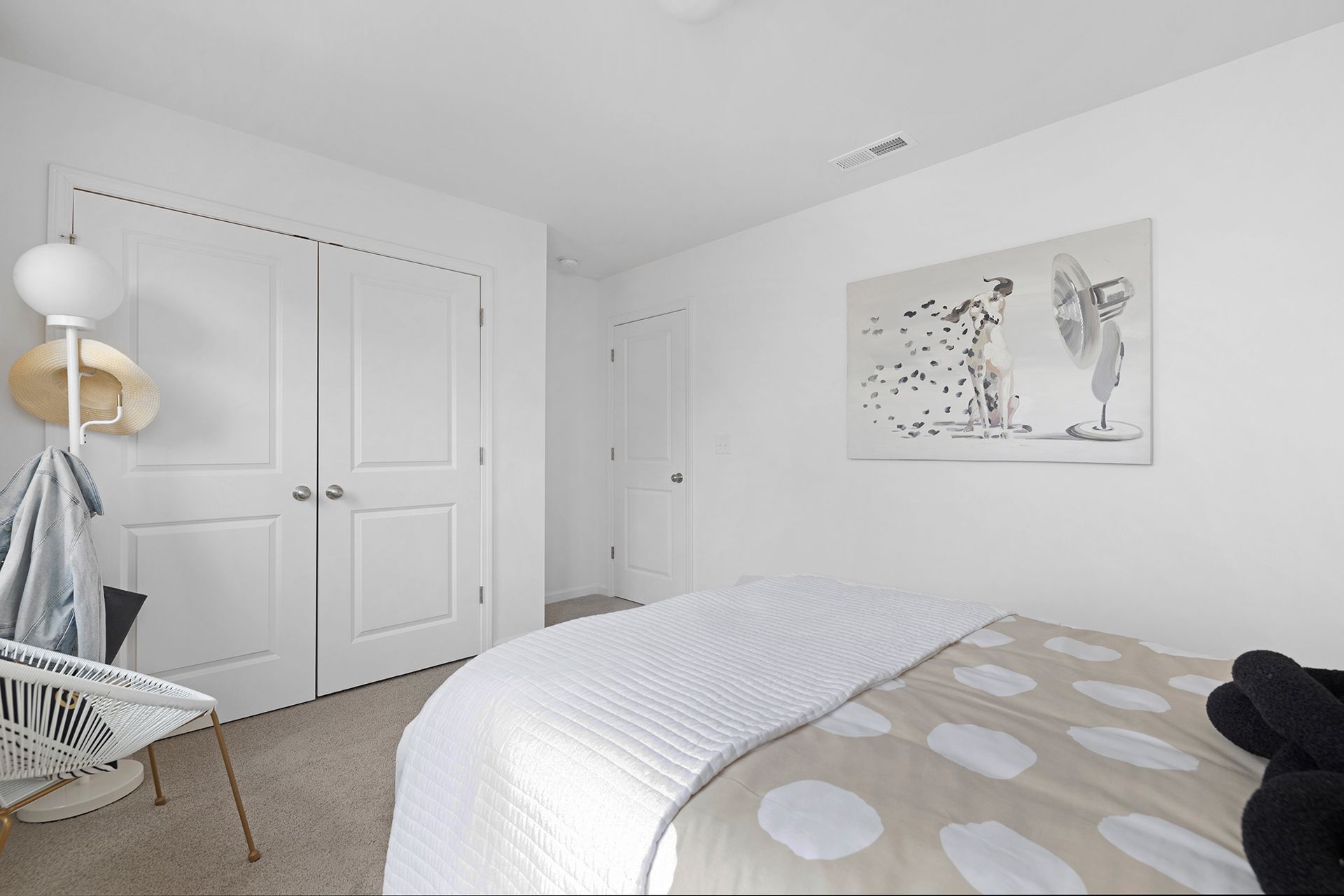 A bedroom with a bed and a painting on the wall.